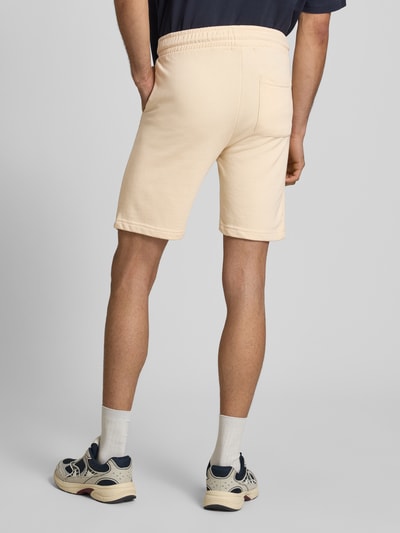 Männermodel trägt Sweatshorts mit elastischem Bund Modell 'KARLOS' von Blend in Beige, mittlere Länge, Regular Fit, Ganzkörperansicht Rückansicht. Baumwoll-Mix, Tunnelzug, Bundweite 42 cm, Innenbeinlänge 21 cm bei Größe M.