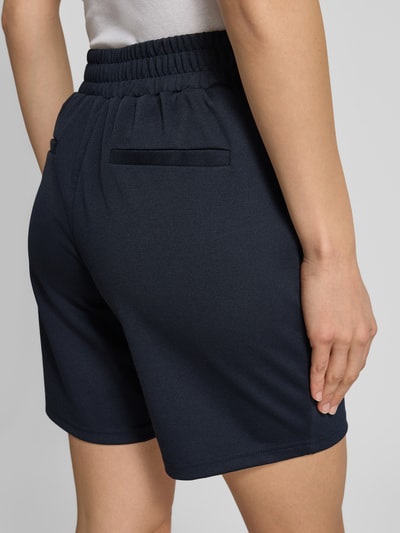 Vrouwenmodel draagt Shorts met elastische tailleband model 'Kate' van ICHI, regular fit, materiaal-mix met viscose, detailopname rugaanzicht.