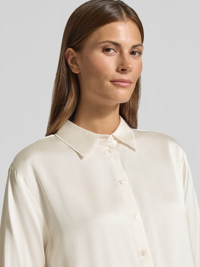 Kobiece modelka nosi Relaxed Fit Hemdbluse aus Viskose-Mix od COMMA, kołnierzyk koszulowy, listwa guzikowa, długi rękaw, mieszanka wiskozy, długość tyłu 69 cm, długość rękawa 60 cm, kremowy kolor, gładka tekstura, zbliżenie na górną część ciała.