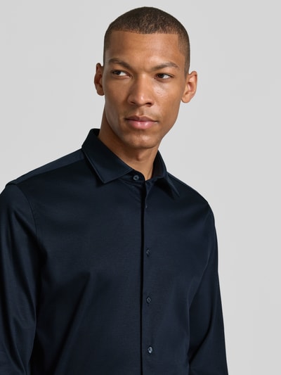 Männermodel trägt Slim Fit Business-Hemd mit Kentkragen von Roy Robson aus Reine Baumwolle, dunkelblauer Stoff, Nahaufnahme Oberkörper. Rückenlänge 74 cm, Schulterbreite 44 cm, Ärmellänge 68 cm, Knopfleiste, Sportmanschetten.