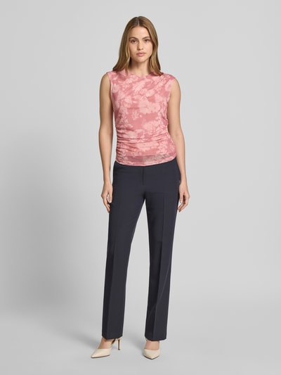 Frauenmodel trägt T-Shirt mit Raffungen und Rundhalsausschnitt von Jake*s Collection im Material-Mix mit Stretch-Anteil, körpernaher Schnitt, Farbe Rosa gemustert, zu schwarzer Hose kombiniert, Ganzkörperansicht von vorne.