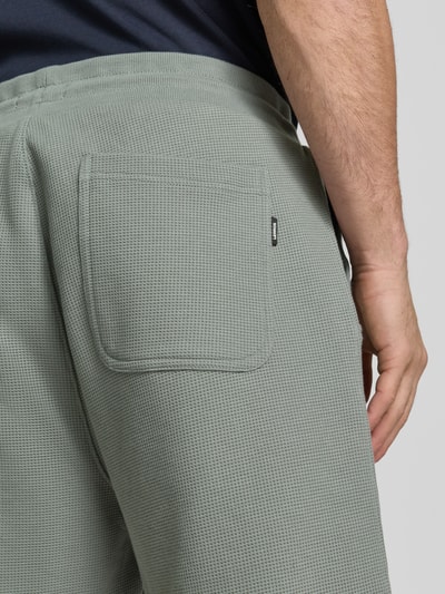 Männermodel trägt Shorts mit Strukturmuster und Tunnelzug von Lerros aus Baumwoll-Mix mit Stretch-Anteil, Gesäßtasche, Nahaufnahme Rückansicht.