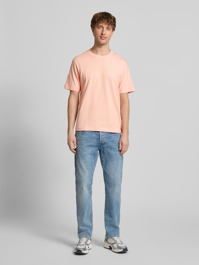 Männermodel trägt T-Shirt mit Label-Stitching Modell 'NORREBRO' von Jack & Jones in Rosa, Baumwolle, Regular Fit, Ganzkörperansicht von vorne.