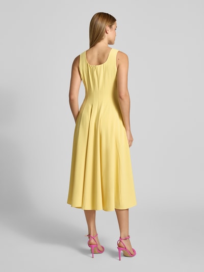 Frauenmodel trägt Midikleid mit Rundhalsausschnitt Modell 'ARLOTT' von Ted Baker in Hellgelb, A-Linie, breite Träger, Ganzkörperansicht Rückansicht