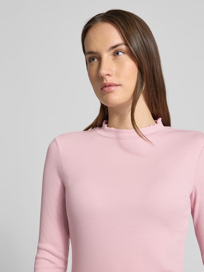 Frauenmodel trägt Slim Fit Langarmshirt aus Baumwoll-Mix von Tom Tailor Denim in Rosa, fein gerippt, hoher Ausschnitt, Nahaufnahme Oberkörper.