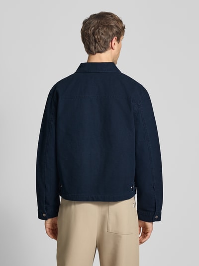 Männermodel trägt Regular Fit Übergangsjacke in Denim-Optik von REVIEW in Dunkelblau, Reine Baumwolle, Rückansicht, Ganzkörperansicht Rückansicht. Rückenlänge 66 cm, Schulterbreite 50 cm, Brustweite 59 cm, Ärmellänge 66 cm, Umlegekragen, Reißverschluss, geteilte Kängurutasche.