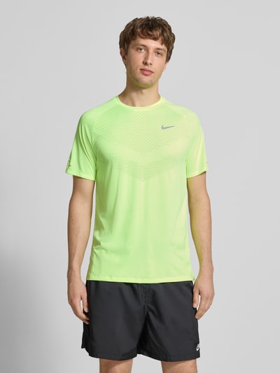 Männermodel trägt Funktionsshirt mit Logo und Rundhalsausschnitt Modell 'Stride' von NIKE TRAINING in Neongelb, Regular Fit, Ganzkörperansicht von vorne.