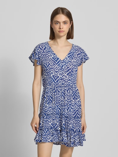 Frauenmodel trägt tailliertes Freizeitkleid aus reiner Viskose Modell 'CLAUDETTE' von Only mit Optik:Allover-Muster in Blau und Weiß, V-Ausschnitt, kurze Knopfleiste, Kurzarm, Volant-Saum, Materialverarbeitung: Webware, Mini-Länge, Ganzkörperansicht von vorne.
