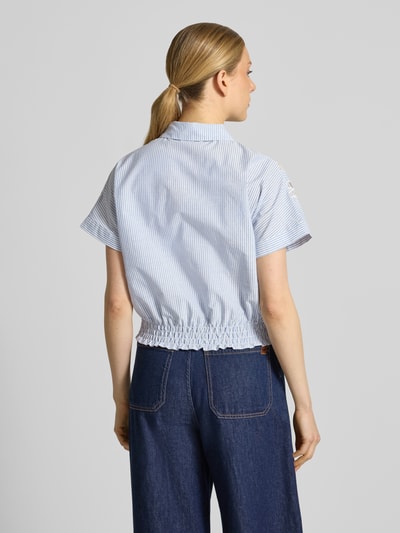 Frauenmodel trägt Regular Fit Hemdbluse mit Häkelspitze Modell 'LOlITA' von SUNCOO PARIS aus Reiner Baumwolle, Rückenansicht, 1/2-Arm, feines Streifenmuster, elastischer Saum, glatte Textur, Ganzkörperansicht Rückansicht.