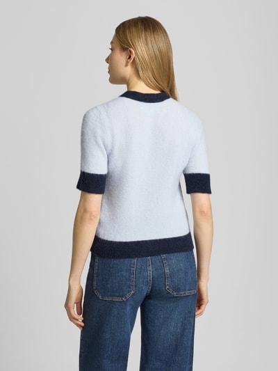Frauenmodel trägt Regular Fit Cardigan aus Woll-Alpaka-Mix Modell 'Sanoura' von Samsøe Samsøe in Hellblau mit dunklen Bündchen, Strick-Optik, elastisches Material, Rundhalsausschnitt, durchgehende Knopfleiste, Rückansicht Ganzkörperansicht.