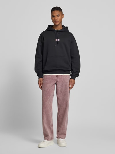 Männermodel trägt Loose Fit Jeans im 5-Pocket-Design Modell 'Roy' von Les Deux in Rosa, gerader Schnitt, Ganzkörperansicht von vorne.