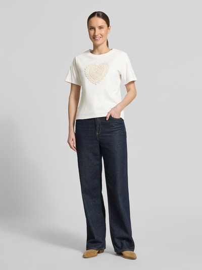 Vrouwenmodel draagt T-shirt met motiefstitching en ronde hals van Christian Berg Woman, puur katoen, regular fit, ruglengte maat S 53 cm, geheelbeeld vooraanzicht.