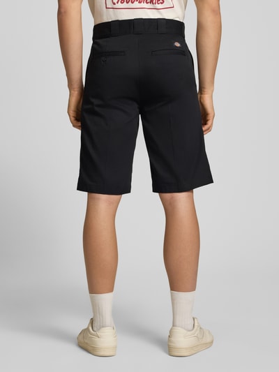 Männermodel trägt Bermudas mit französischen Eingrifftaschen von Dickies aus Reine Baumwolle, Straight Fit, klassisch schwarz, Ganzkörperansicht Rückansicht.