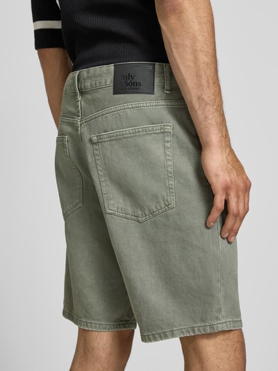 Männermodel trägt Regular Fit Jeansshorts aus reiner Baumwolle Modell 'EDGE' von Only & Sons in Denim-Optik, Label-Patch, Nieten, 5-Pocket-Design, Detailaufnahme Rückansicht.