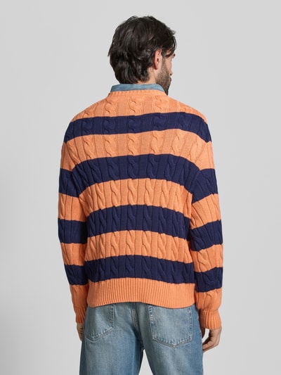 Männermodel trägt Regular Fit Strickpullover aus reiner Baumwolle von Polo Ralph Lauren, dwukolorowy, dzianina w warkocze, detal z logo, długi rękaw, okrągły dekolt, bawełna, krój regular fit, całkowity widok z tyłu