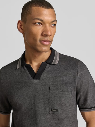 Männermodel trägt Regular Fit Poloshirt aus reiner Baumwolle Modell 'OPEN COLLAR POLO' von s.Oliver RED LABEL in grauer Melange-Optik mit Brusttasche, Label Stitching, Piqué-Struktur und geripptem Kurzarm, Nahaufnahme Oberkörper.