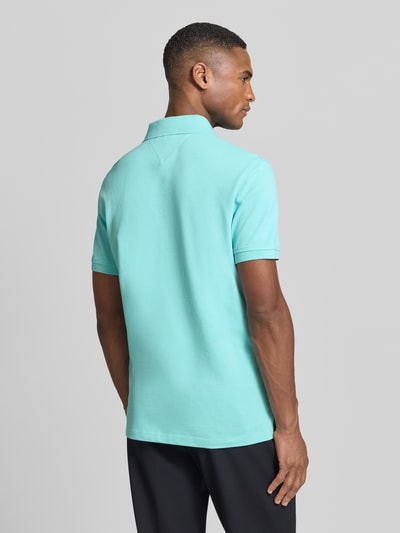 Männermodel trägt Regular Fit Poloshirt aus Baumwoll-Mix von Tommy Hilfiger, Optik: Unifarben, Piqué, Ganzkörperansicht Rückansicht.