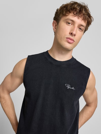 Männermodel trägt schwarzes Tanktop mit Label-Stitching und Rundhalsausschnitt von Pegador aus Reine Baumwolle, Relaxed-Fit, Nahaufnahme Oberkörper. Rückenlänge bei Größe M: 66 cm.
