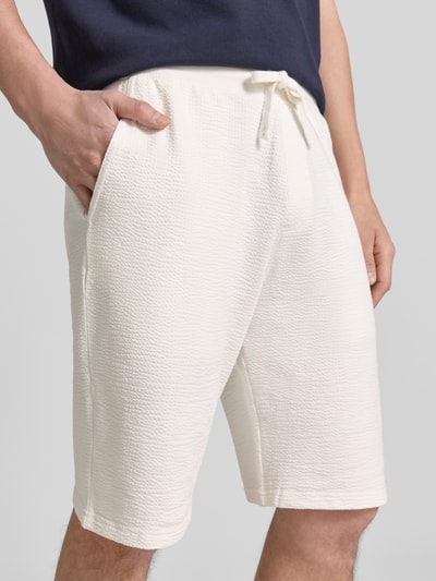 Männermodel trägt Relaxed Fit Bermudas aus Baumwoll-Mix Modell 'DETROIT' von s.Oliver RED LABEL, unifarben mit Waffelstruktur, Nahaufnahme Oberkörper.