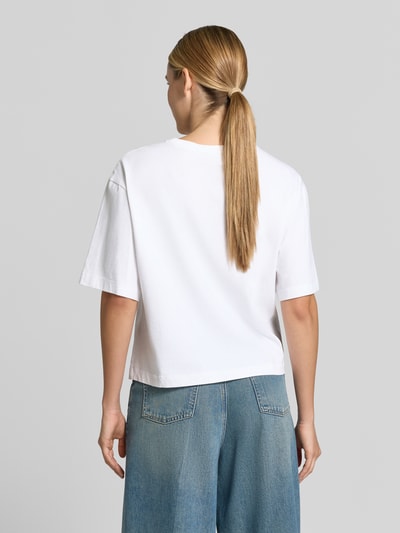 Vrouwenmodel draagt T-shirt uit katoen van Rich & Royal, los model, ronde hals, geborduurd detail, ruglengte maat S: 54 cm, geheelbeeld achteraan.