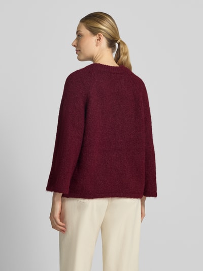 Vrouwenmodel draagt gebreide pullover met Raglanmouwen van FREE/QUENT in bordeaux, materiaalmix met wol, recht model, ruglengte maat S 54 cm, mouwlengte maat S 50 cm, ronde hals, volledig lichaamsbeeld achteraan.