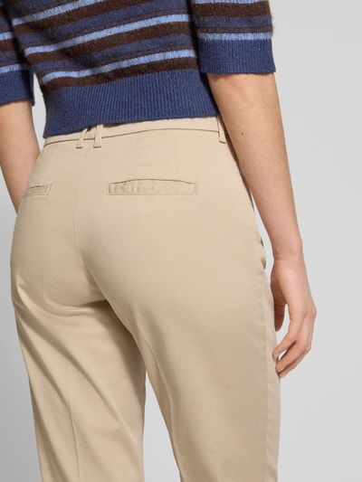 Vrouwenmodel draagt Straight Fit Stoffhose met Lyocell-Anteil Modell 'Mara' van Brax, zandkleur, detailopname achteraan, elastische katoenmix, verkorte pasvorm, persplooien, steek- en achterzakken, knoop- en ritssluiting, context: damesstofhose, taillewijdte bij maat 36: 39 cm, binnenbeenlengte bij maat 36: 68 cm.