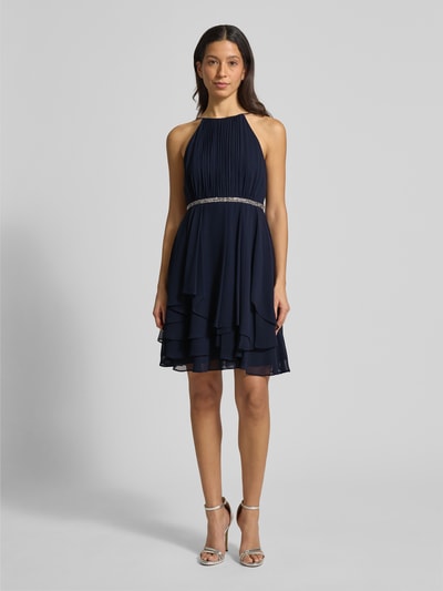 Frauenmodel trägt Cocktailkleid mit Nahtreißverschluss von Jake*s Cocktail, Dunkelblau, taillierter Schnitt, Rundhalsausschnitt, blickdichtes Unterkleid, Rückenlänge 92 cm, Brustweite 33 cm, Ganzkörperansicht von vorne.
