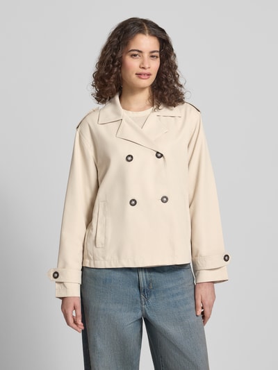 Frauenmodel trägt Regular Fit Trenchcoat-Jacke mit Reverskragen Modell 'HANNAH' von Only, unifarben, doppelreihige Knopfleiste, lange Ärmel, seitliche Eingrifftaschen, Schulterriegel, Rückenpasse, Ganzkörperansicht von vorne.