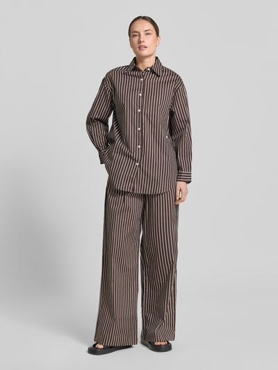 Frauenmodel trägt Damen Weite Hose aus reiner Baumwolle Modell 'MAVIE' von VILLA SOPHIE mit Optik:Allover-Muster, Regular-Fit, High-Waist, elastischer Bundabschluss, seitliche Eingrifftaschen, Label-Patch, Material: reine Baumwolle, warme Braun- und Cremetöne, weiche glatte Textur, Ganzkörperansicht von vorne.