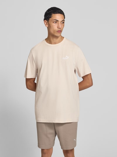 Männermodel trägt Regular Fit T-Shirt mit Logo-Stitching von PUMA PERFORMANCE in Beige, reine Baumwolle, Rundhalsausschnitt, Ganzkörperansicht von vorne.