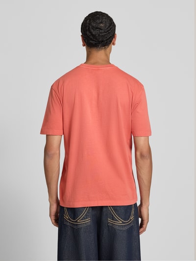 Männermodel trägt Regular Fit T-Shirt aus reiner Baumwolle Modell 'John Tee' von Pepe Jeans in Koralle, Ganzkörperansicht Rückansicht. Herren T-Shirt von Pepe Jeans.