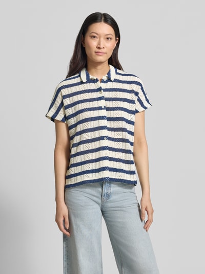 Frauenmodel trägt Regular Fit Poloshirt mit durchgehender Knopfleiste von Christian Berg Woman, gestreifte Struktur in Blau und Creme, reine Baumwolle, Allover-Look, Ganzkörperansicht von vorne.