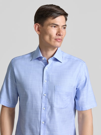 Męski model nosi Modern Fit Business-Hemd mit Kentkragen von ETERNA, mieszanka bawełny i lyocellu, rękaw o dł. 1/2, listwa guzikowa, brustasza; jasnoniebieski kolor, gładka struktura, widoczny subtelny wzór; widok z przodu, zbliżenie na górną część ciała.
