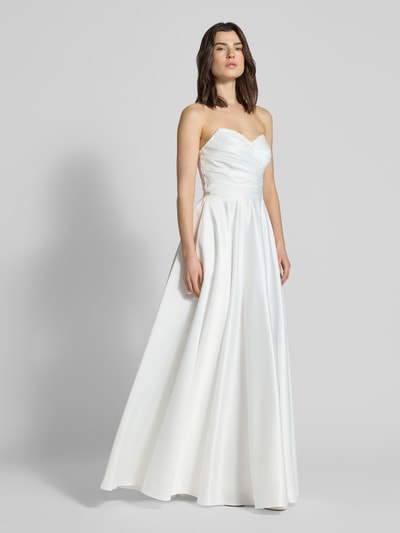 Frauenmodel trägt Brautkleid mit Herz-Ausschnitt von Mascara aus Satin in Weiß, taillierte Passform, Maxilänge, floraler Spitzenbesatz, Zierperlen, Ganzkörperansicht von vorne.
