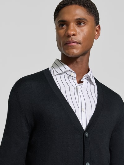 Männermodel trägt Cardigan aus Woll-Mix mit V-Ausschnitt von Christian Berg Men, körpernaher Schnitt, Nahaufnahme Oberkörper.