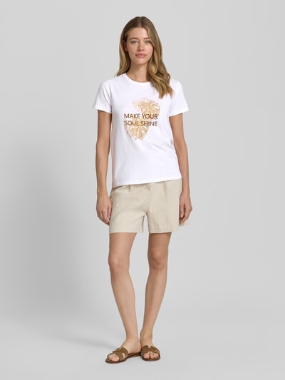 Frauenmodel trägt Damen T-Shirt mit Statement- und Motiv-Print Modell 'RINA' von Soyaconcept, Reine Baumwolle, Regular-Fit, Rundhalsausschnitt, Rückenlänge bei Größe S 60 cm, helle Farben, Ganzkörperansicht von vorne.