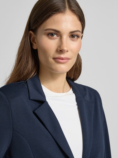 Frauenmodel trägt Blazer mit Raffungen Modell 'Siham' von Soyaconcept aus Elastischer-Material-Mix in Dunkelblau, Nahaufnahme Oberkörper. Passform tailliert, Reverskragen, Knopfverschluss laut Kontext.