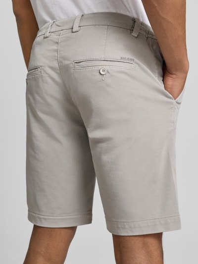 Männermodel trägt Bermudas mit Bindegürtel und französischen Eingrifftaschen von MAC aus Baumwoll-Mix mit Stretch-Anteil, Ganzkörperansicht Rückansicht.