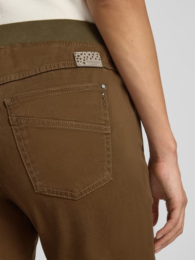 Frauenmodel trägt Schmale Hose aus Baumwoll-Mix Modell 'PAMINA' von Raphaela By Brax in Braun, Detailaufnahme Rückansicht, Material Webware, 5-Pocket-Design, elastischer Bund, Label Patch.