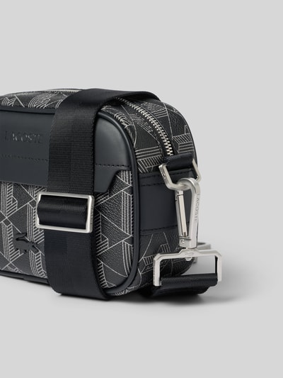 Produktfoto, REPORTER BAG von Lacoste für Herren mit schwarzem geometrischem Muster, glänzende Metallschnallen, strukturierte Oberfläche