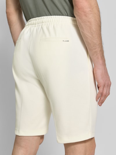 Mężczyznamodel nosi Regular Fit Shorts mit Tunnelzug od Antony Morato, kolor jasny beż, materiał z bawełną, elastyczny pas, szerokość w rozmiarze M: 41 cm, długość wewnętrzna nogawki: 25 cm, widok całej sylwetki z tyłu.