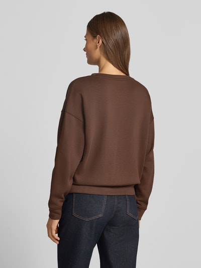 Frauenmodel trägt Relaxed Fit Sweatshirt mit elastischen Abschlüssen von MSCH Copenhagen in Braun, kombiniert mit Jeans, Ganzkörperansicht Rückansicht. Viskose-Mix mit Stretch-Anteil, Rundhalsausschnitt, schlichte Textur.