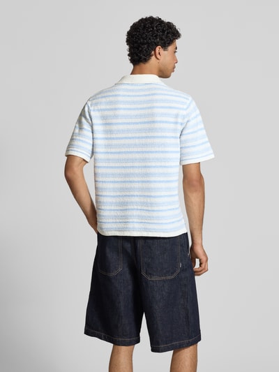 Männermodel trägt Modern Fit Poloshirt mit kurzer Knopfleiste Modell 'HYERES' von Jack & Jones, Strukturmuster, Rückenlänge 67 cm, Material-Mix, Ganzkörperansicht Rückansicht.