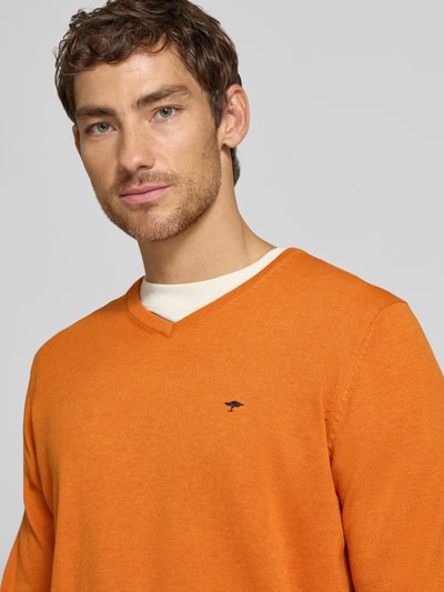 Männermodel trägt Strickpullover mit Label-Strickerei von Fynch-Hatton in Orange, V-Ausschnitt, reine Baumwolle, Nahaufnahme Oberkörper.