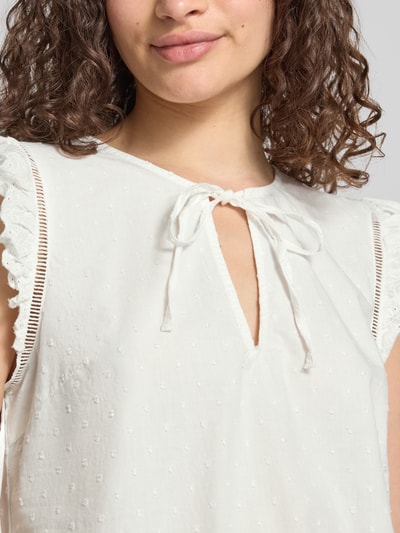 Frauenmodel trägt weißes Regular Fit Blusentop aus reiner Baumwolle Modell 'GOLDIE' von PIECES, zarte Struktur, Nahaufnahme Oberkörper. Damen Blusentop von PIECES.