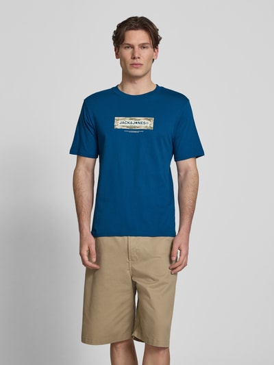 Männermodel trägt T-Shirt mit Logo und Rundhalsausschnitt von Jack & Jones, reine Baumwolle, Regular Fit, Blau, Logo-Print, Ganzkörperansicht von vorne.