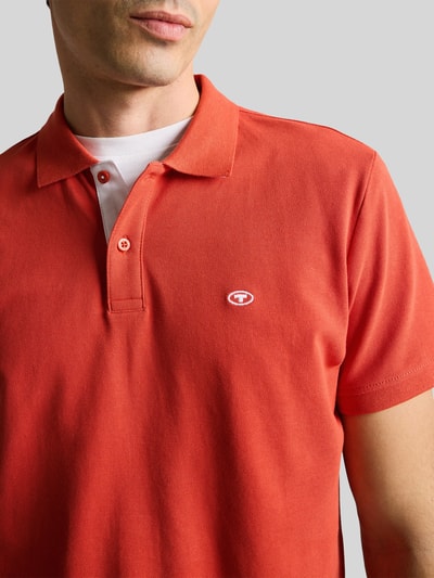 Mannenmodel draagt Regular Fit Poloshirt uit zuivere katoen van Tom Tailor, effen, piqué, korte mouw, polokraag, logo-stiksel, close-up bovenlichaam