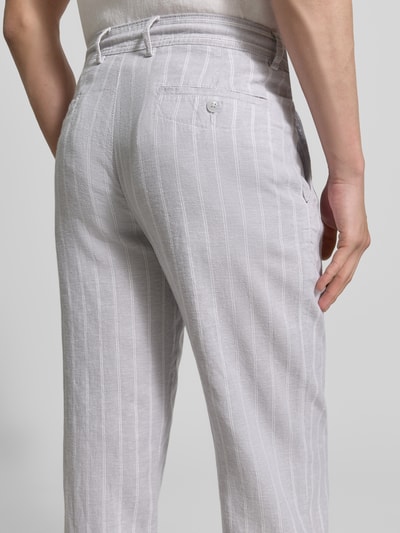 Männermodel trägt Regular Fit Hose aus Leinen-Viskose-Mix von MCNEAL in Hellgrau mit weißen Streifen, Gesäßtasche, Detailaufnahme Rückansicht, Bundweite 46 cm, Innenbeinlänge 84 cm, Größe M, mit Eingrifftaschen.