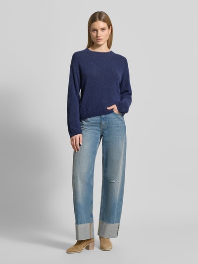 Frauenmodel trägt Strickpullover mit überschnittenen Schultern Modell 'Mape' von MOS MOSH, dunkelblau, Woll-Mix, gerader Schnitt, Rundhalsausschnitt, Jeans und Stiefeletten, weiche Textur, Ganzkörperansicht von vorne.