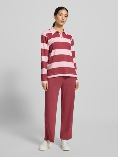 Frauenmodel trägt Sweatshirt mit Polokragen Modell 'BARNI' von Soyaconcept im Material-Mix, pink-rote Streifen, lockerer Schnitt, Ganzkörperansicht von vorne.